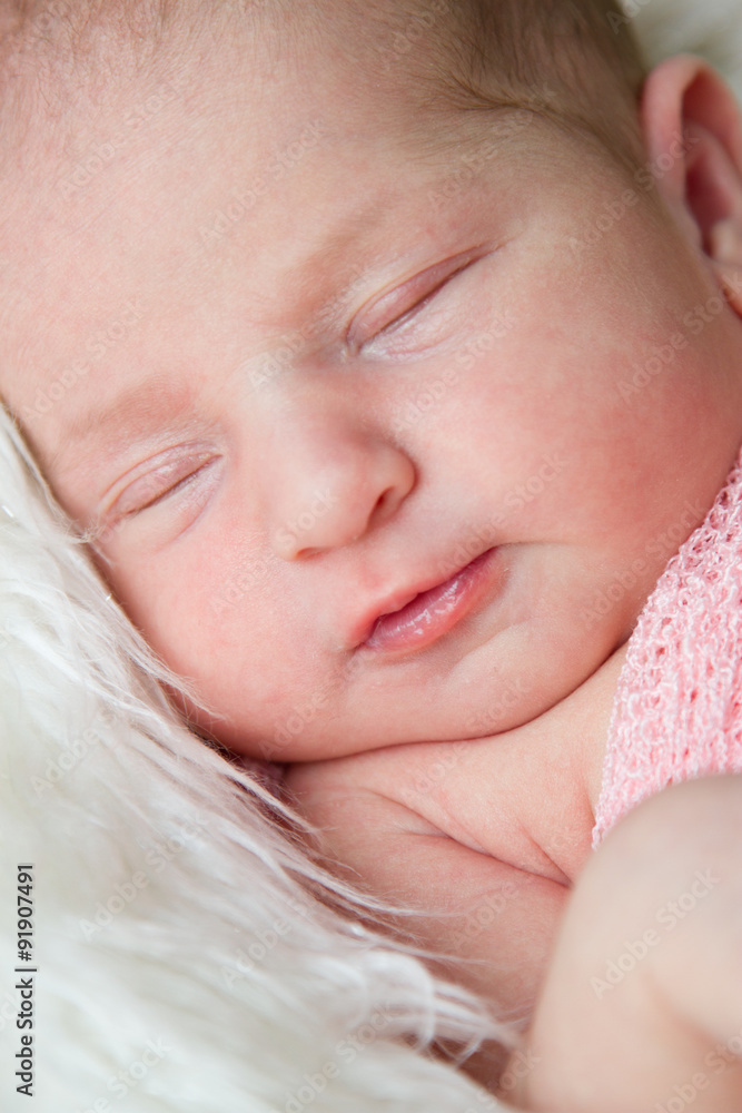7 day old newborn baby girl sleeping in a bowl with light pink background 7 day old newborn baby girl sleeping in a bowl with light pink background