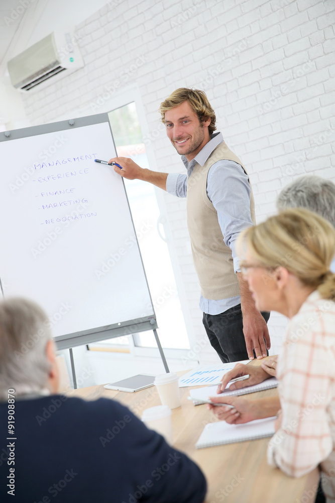 Business instructor leading meeting with senior training group Business instructor leading meeting with senior training group