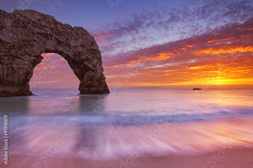 Durdle Door rock arch in Southern England at sunset