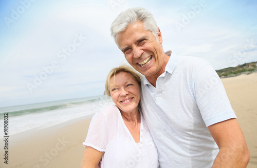Married senior couple having fun walking in the beach