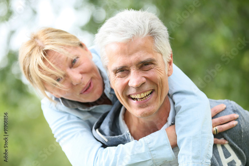 Senior man giving piggyback ride to his wife