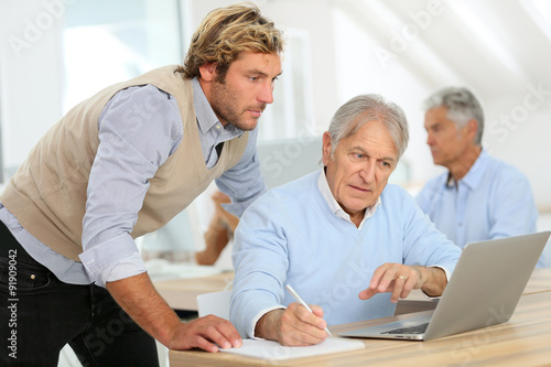 Senior man attending business class with trainer