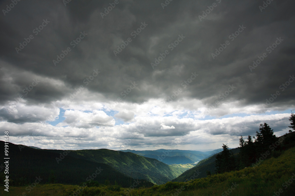 Landscape green mountains on a background of storm clouds
