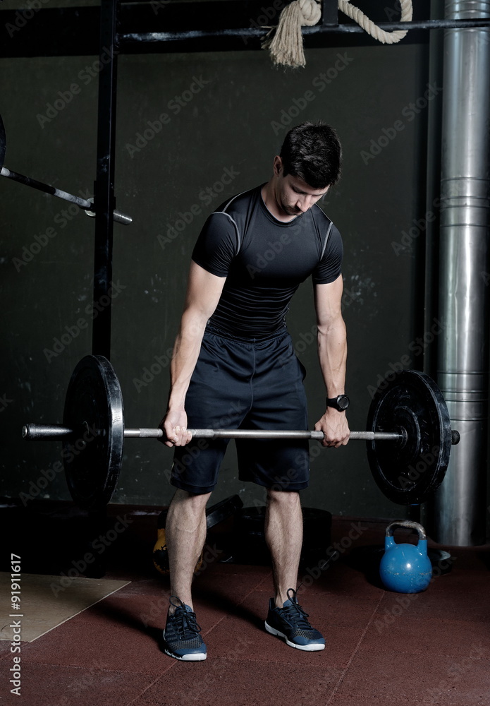 Athlete Fitness trainer working out / weight lifting in a gym Athlete Fitness trainer working out / weight lifting in a gym