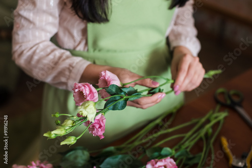 Woman florist holding a bouquet of roses to a wedding
