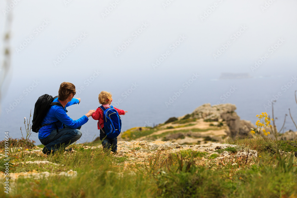 father and little daughter hiking in mountains