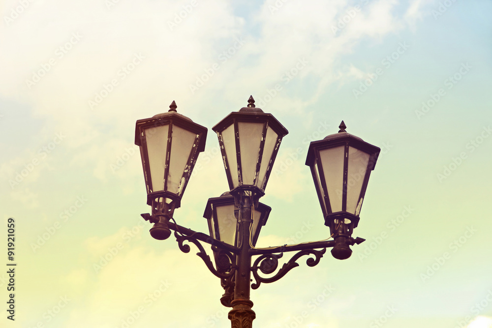 Vintage street light against blue sky.