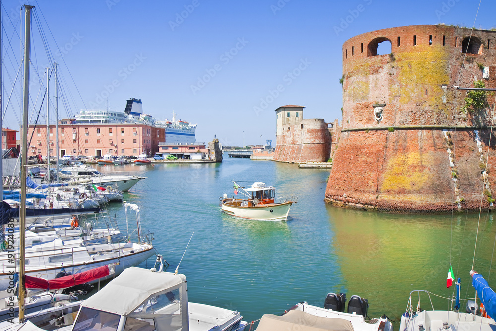 The Livorno's harbour with a ship sailing to the main Italian island - obrazy, fototapety, plakaty 