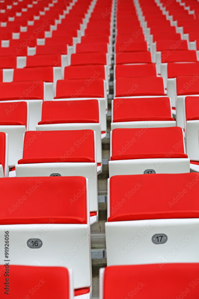 Obraz premium Czerwone fotele dla kibiców na sektorze trybuny nowoczesnego stadionu piłkarskiego