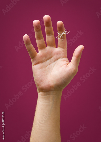 Hand with remider string isolated on red purple plum background photo