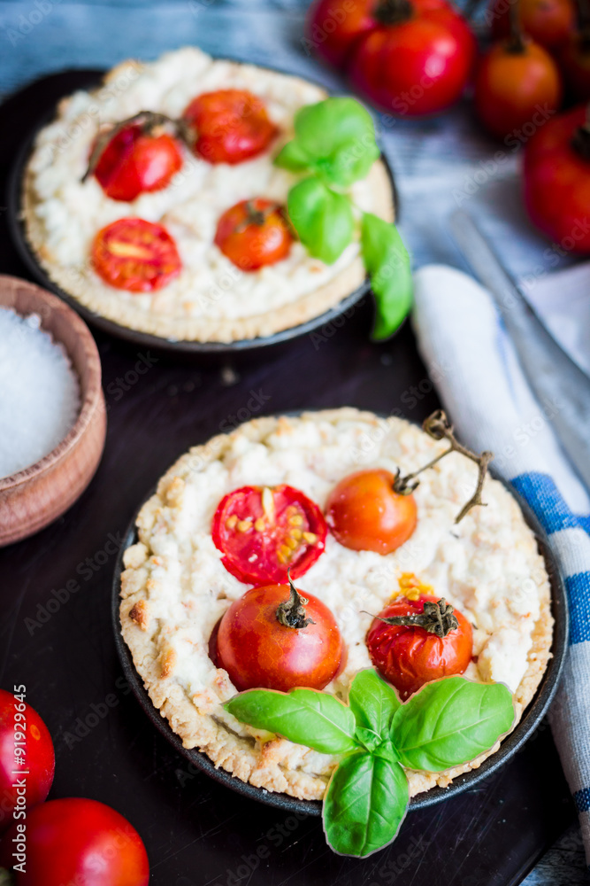 quiche with goat cheese, cherry tomatoes and basil on blue woode quiche with goat cheese, cherry tomatoes and basil on blue woode