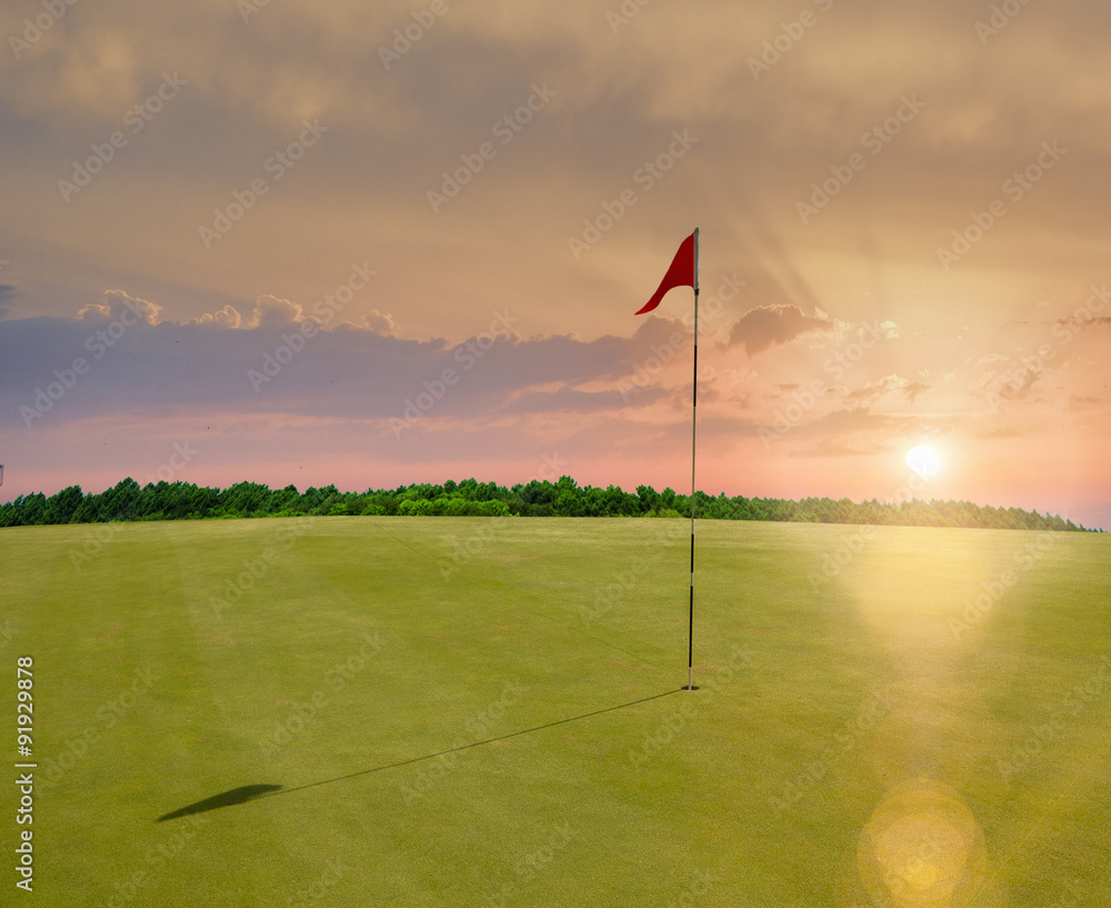 Obraz premium Red flag in a golf course during sunset