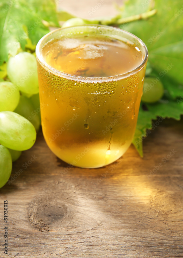 Glass of cool grape juice on wooden table, closeup Glass of cool grape juice on wooden table, closeup