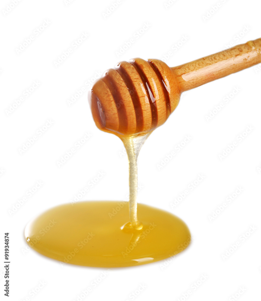 Honey dripping from dipper on light surface Honey dripping from dipper on light surface