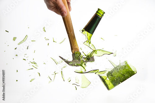 Photography Hammer break a green glass bottle isolated on white background