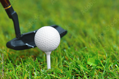 Golf balls and driver on green grass background