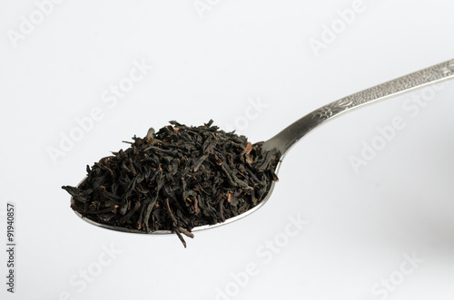 Loose black tea heaped on tea spoon