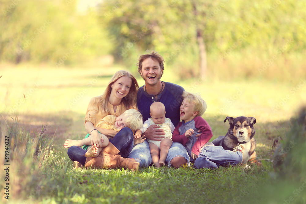 Happy Family Laughing Together with Dog Outside Happy Family Laughing Together with Dog Outside