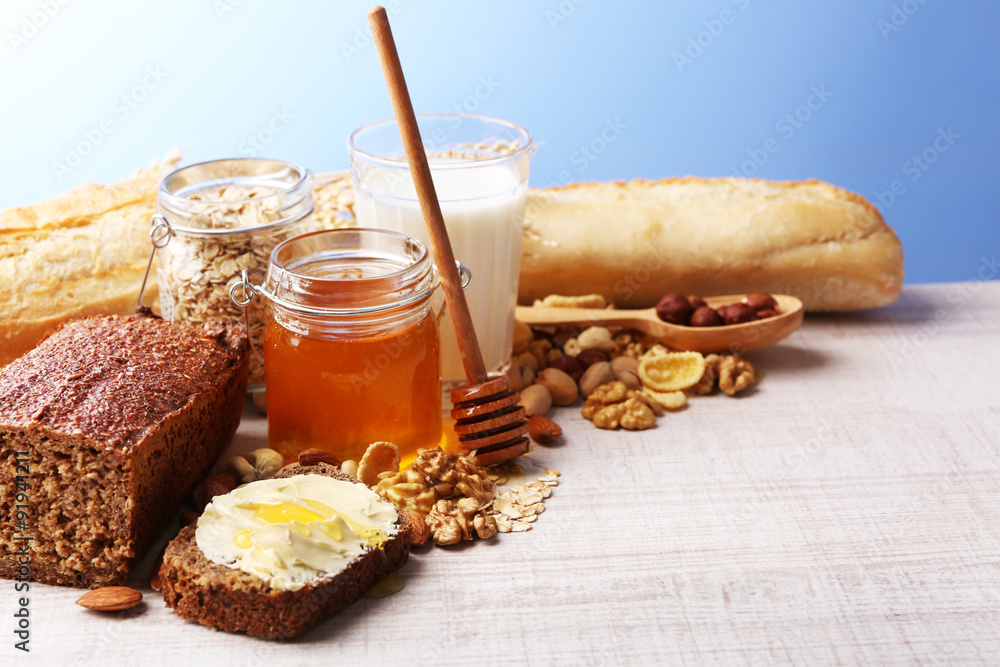 Healthy breakfast with bread, honey, nuts on table, on colorful background. Country breakfast concept Healthy breakfast with bread, honey, nuts on table, on colorful background. Country breakfast concept