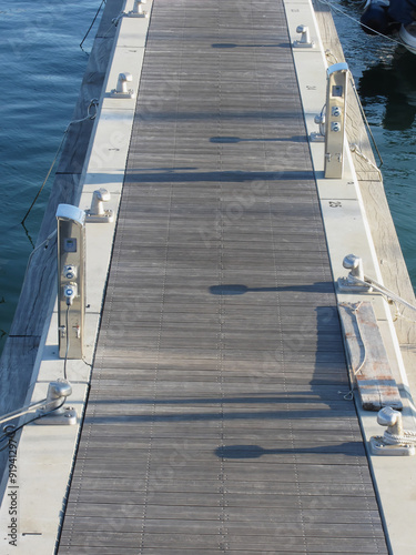 Wooden pier for boats with electricity supply appliances in the harbor in Marina di Pisa, Tuscany, Italy © lukeluke68
