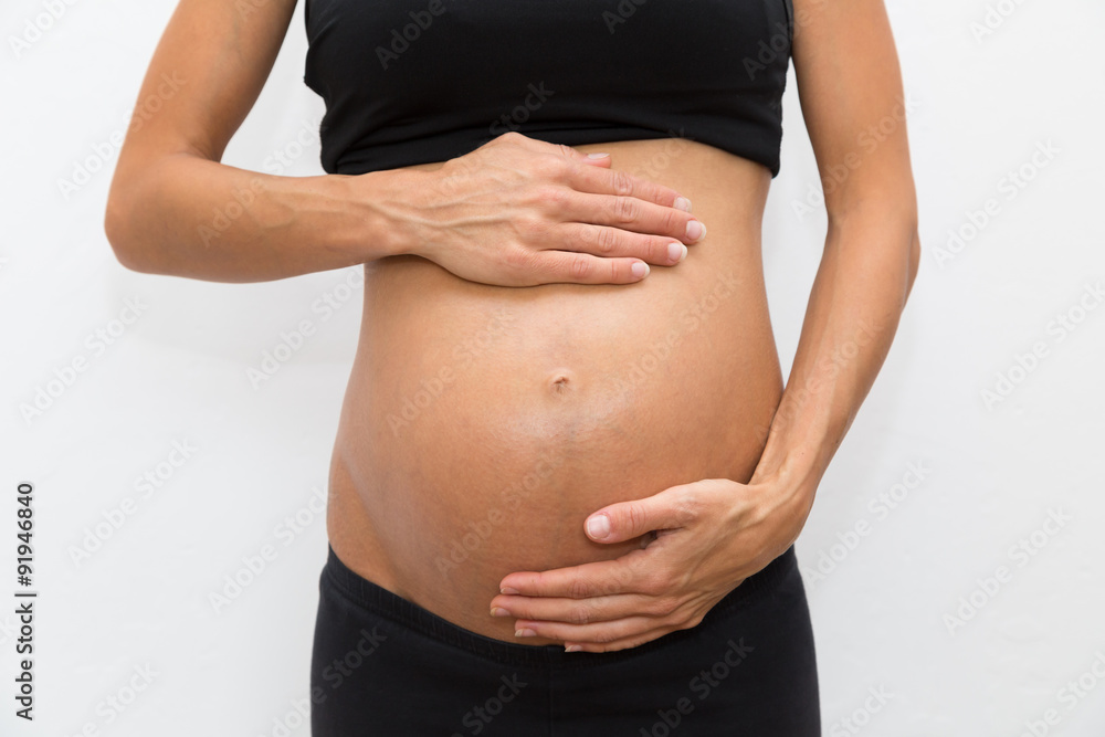 eine schwangere Frau hat ihre Hände auf dem Bauch eine schwangere Frau hat ihre Hände auf dem Bauch