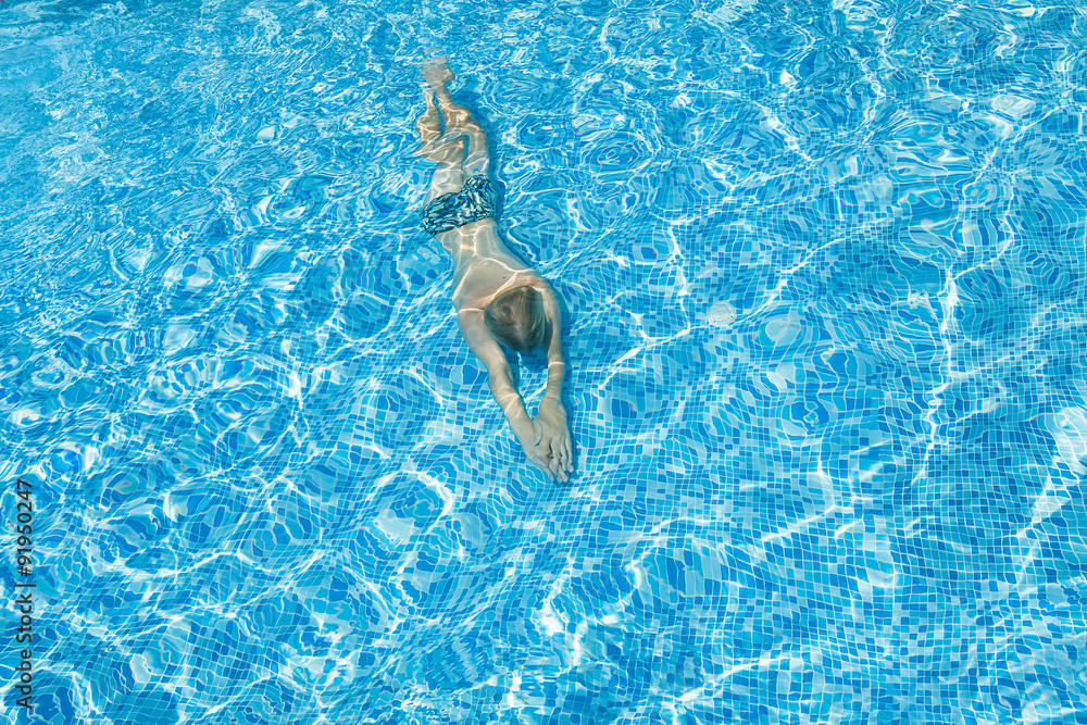 Silhouette of a person swiming in the pool.
