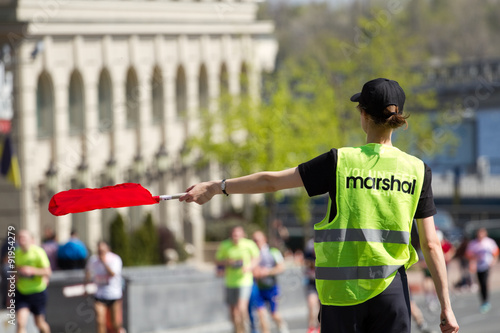 Εκτύπωση καμβά Volunteer Marshal shows the direction of runners