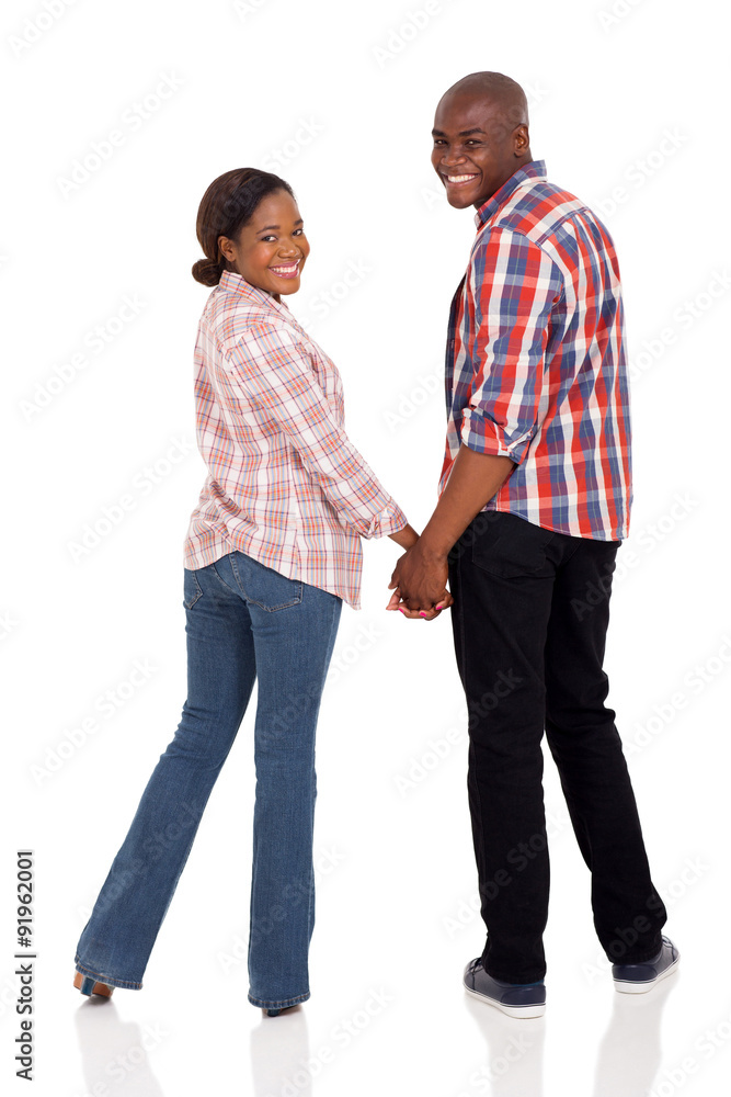 african american couple holding hands and looking back african american couple holding hands and looking back
