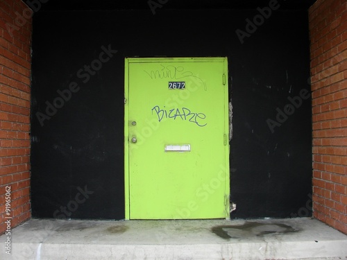 green door with graffiti and brick © jdoms