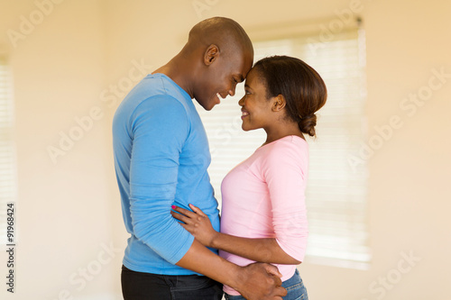 young afro american couple embracing in their home