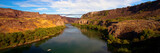 Wide panorama of golden evening light on I. B. Perrine Bridge and the Snake River at Twin Falls, Idaho