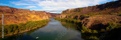 Wide panorama of golden evening light on I. B. Perrine Bridge and the Snake River at Twin Falls, Idaho photo