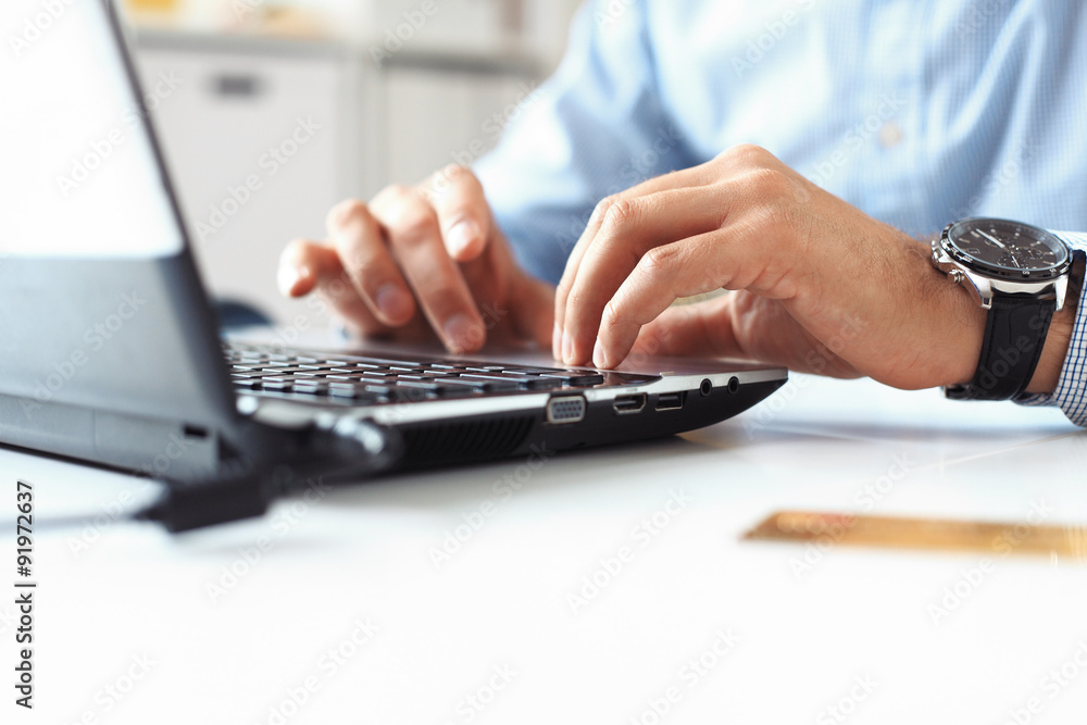 Close-up of male hands typing on laptop keyboard Close-up of male hands typing on laptop keyboard