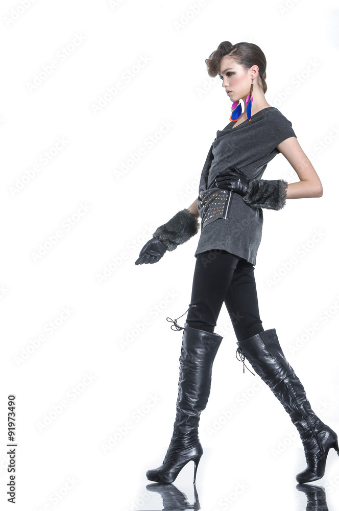 Beautiful fashion model in fashion clothes posing walking in studio Beautiful fashion model in fashion clothes posing walking in studio