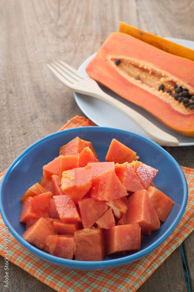 Ripe Papaya slices on a blue plate and wooden floor. Ripe Papaya slices on a blue plate and wooden floor.