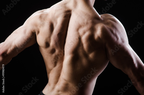 Muscular man posing in dark studio