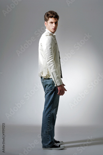 Portrait of a young man standing on light background © glamour111