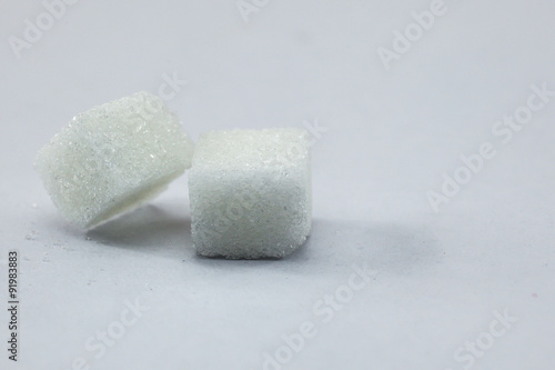Sugar Cubes on Isolated White Background with Harsh Shadow, which can be used to imply dark side of Sugar