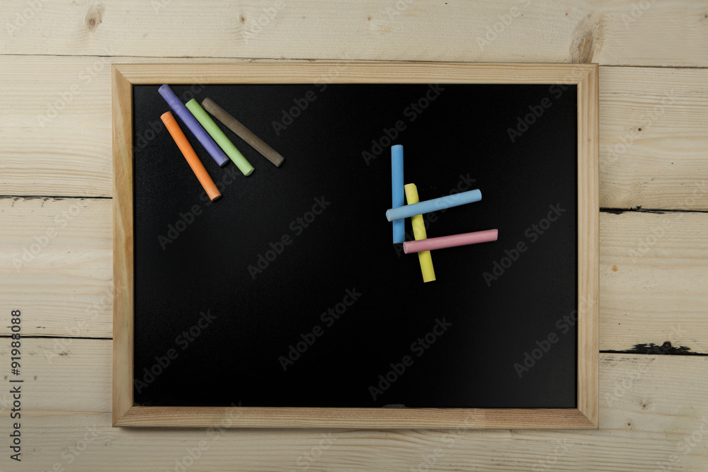 lavagna con gessetti colorati su sfondo di legno Stock Photo | Adobe Stock
