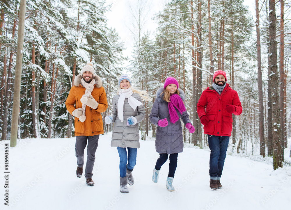 group of smiling men and women in winter forest