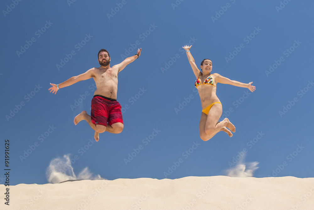 Couple jumping at the beach