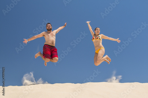 Couple jumping at the beach