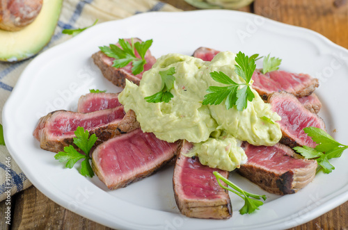 Beef steak with avocado dip and herbs