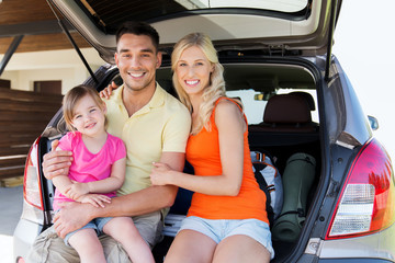 happy family with hatchback car at home parking