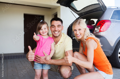 happy family with car showing thumbs up at parking © Syda Productions
