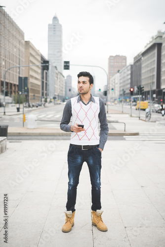 Young handsome indian contemporary business man walking through