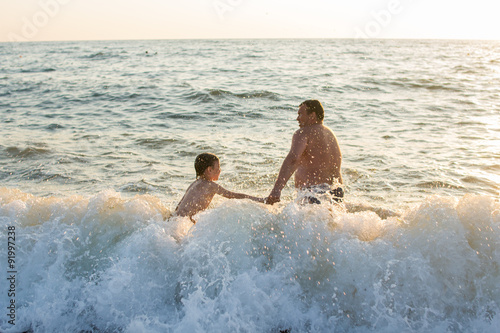 father with son swimming in the sea 