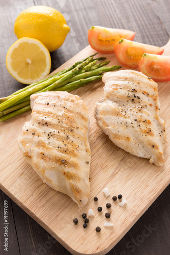 Marinated grilled chicken breasts on the wooden table