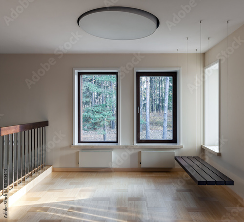 Interior of modern empty space with suspended bench and windows © LuckyPhoto