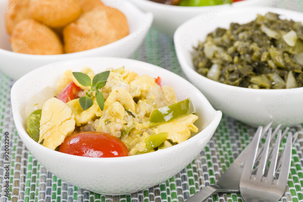 Ackee & Saltfish - Traditional Jamaican dish made of salt cod and ackee fruit. Served with callaloo and johnny cakes.
